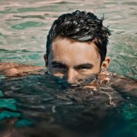 man in water with half face over water