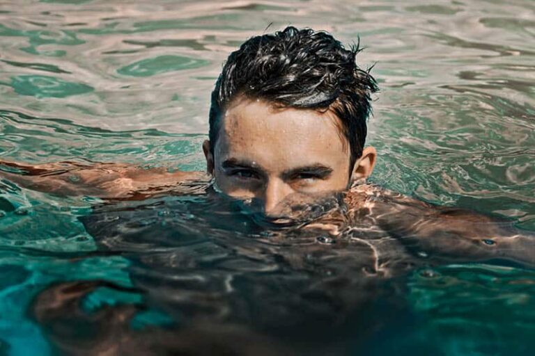 man in water with half face over water