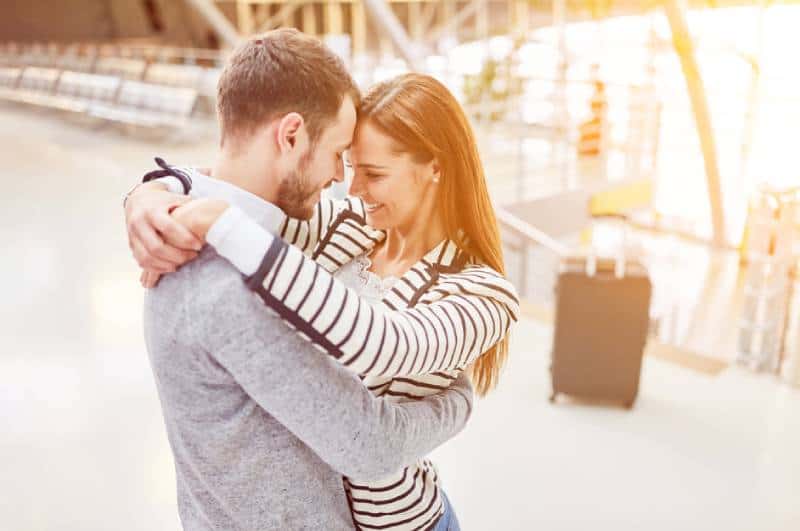Una coppia felice si abbraccia all'aeroporto