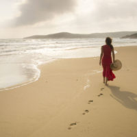 mujer solitaria caminando por la playa