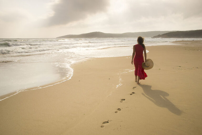 donna sola che cammina sulla spiaggia