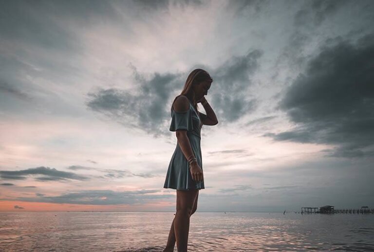 side view of woman standing beside sea