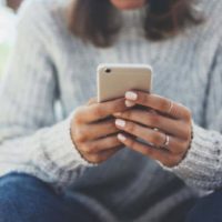 mujer sentada en casa y utilizando un smartphone