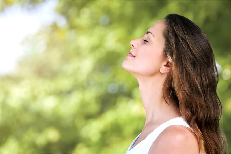 mujer tranquila respirando aire fresco