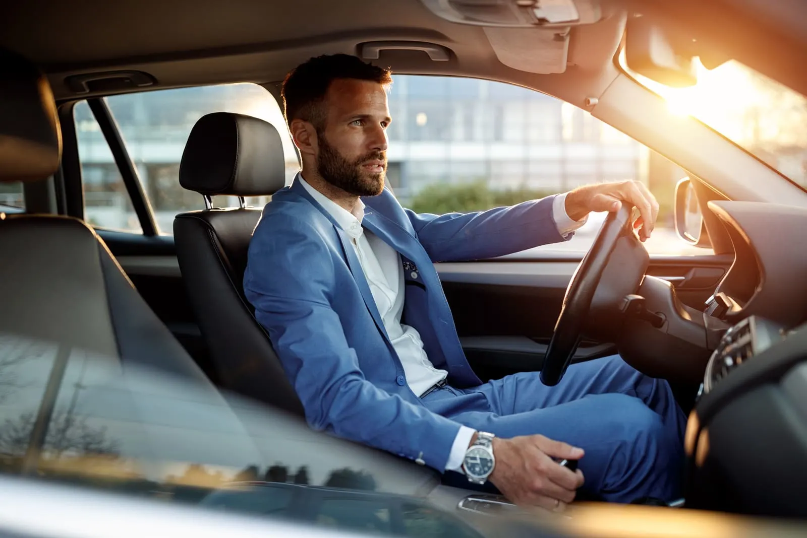 elegant man in business suit driving car