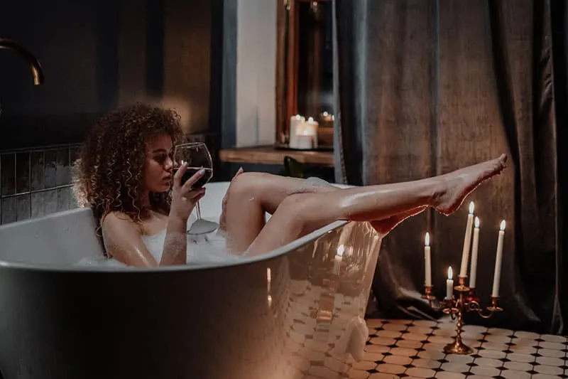 sexy woman having a bath and glass of wine
