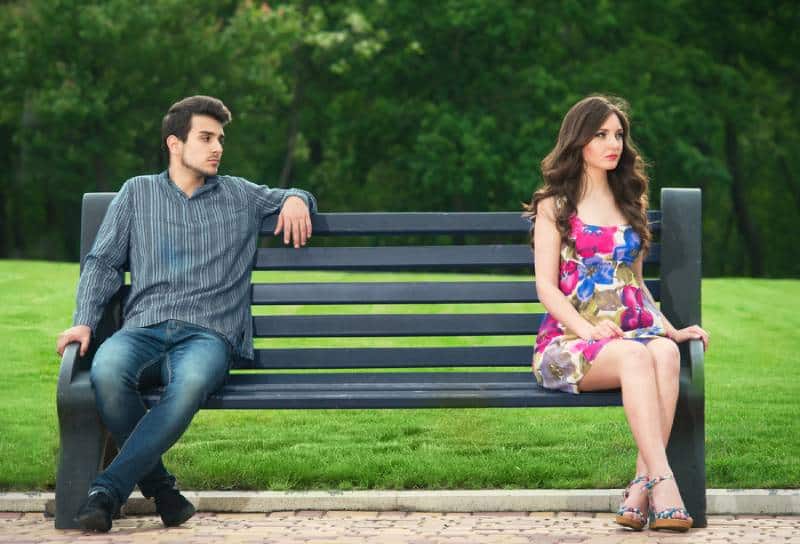 unhappy couple sitting on the bench in the park