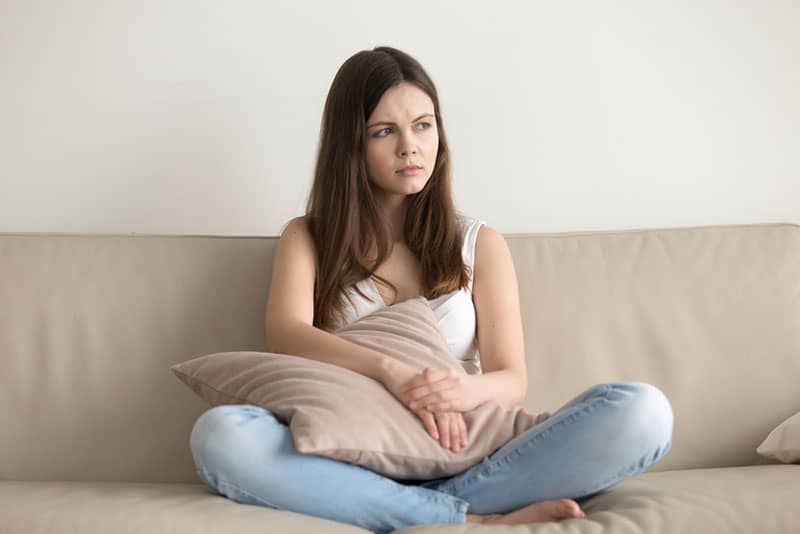 worried woman sitting on the couch