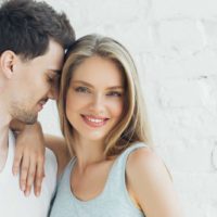 a man leaning his head against his girlfriend’s head