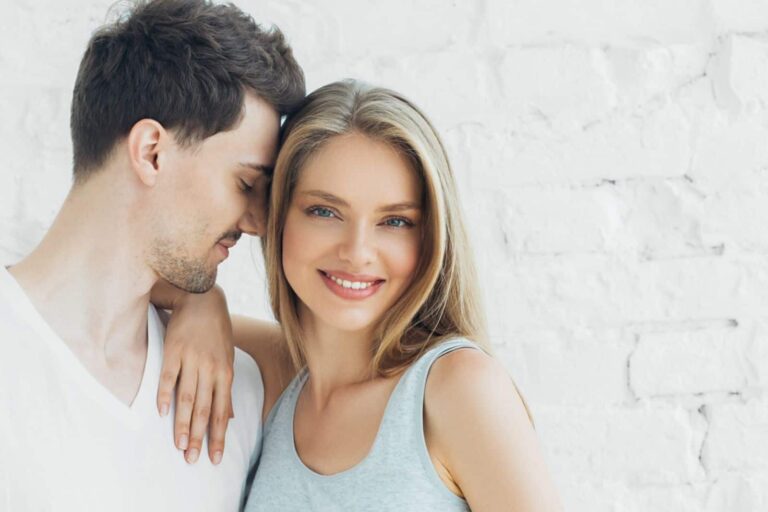 a man leaning his head against his girlfriend’s head