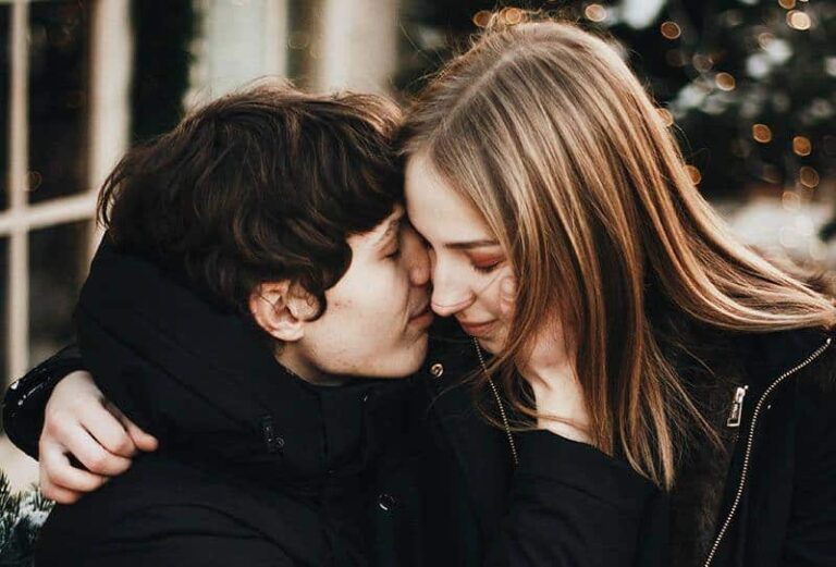 encantadora pareja abrazándose al aire libre