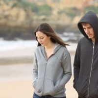 serious couple walking on the beach