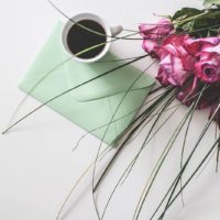 chávena de café e flor no envelope