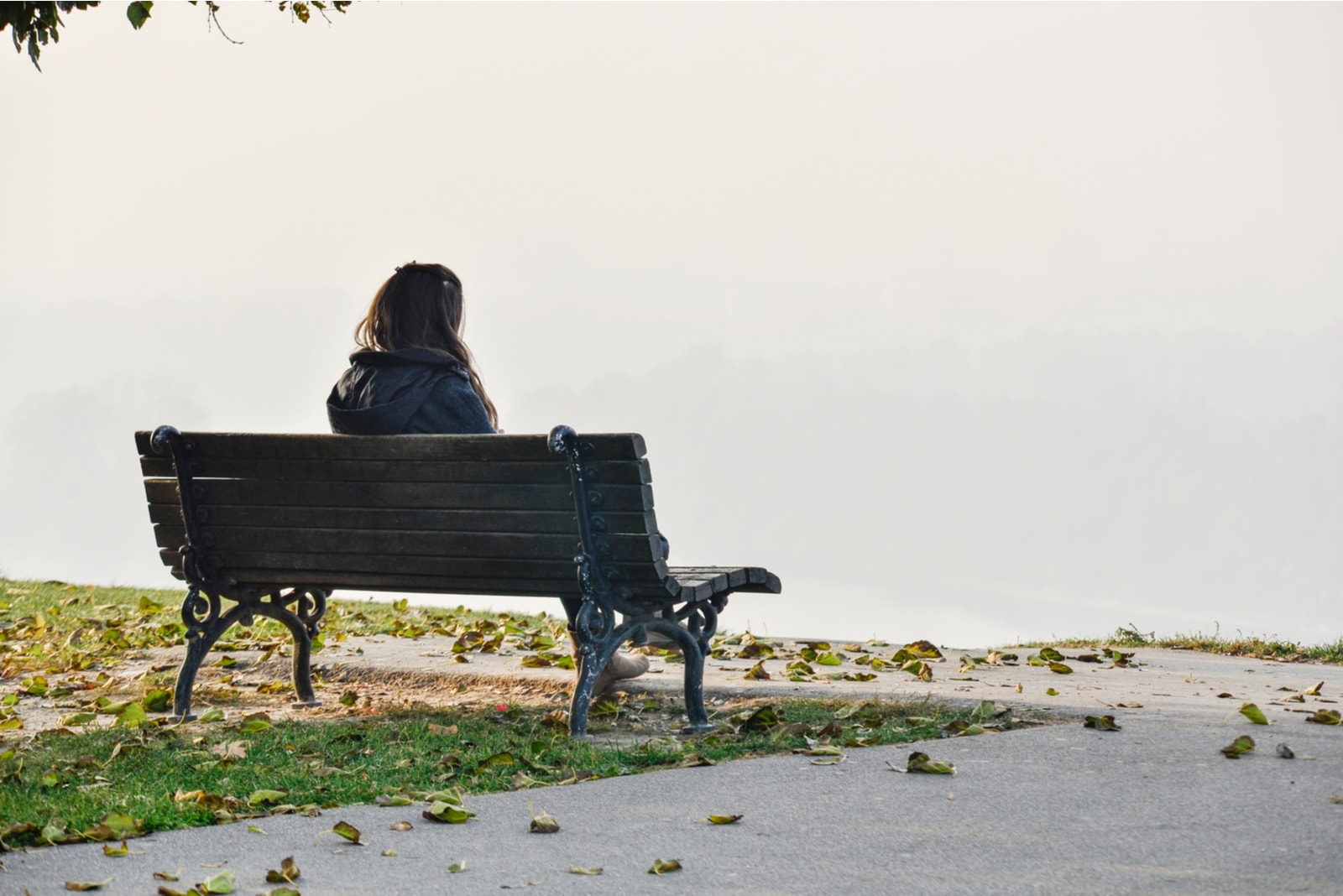 sad woman in nature sitting on the bench
