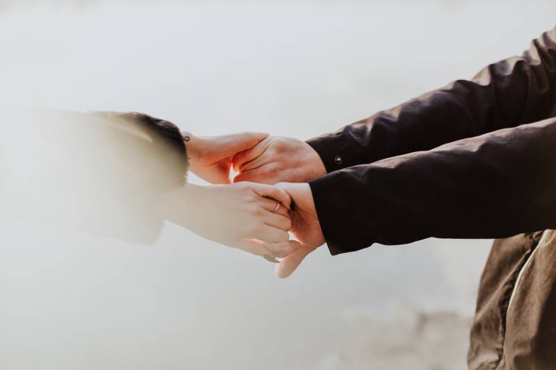 Couple holds their hands outside