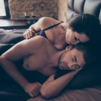 woman kissing man while he sleeps