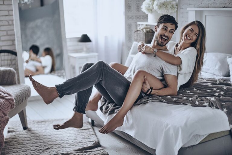 pareja feliz divirtiendose en la cama