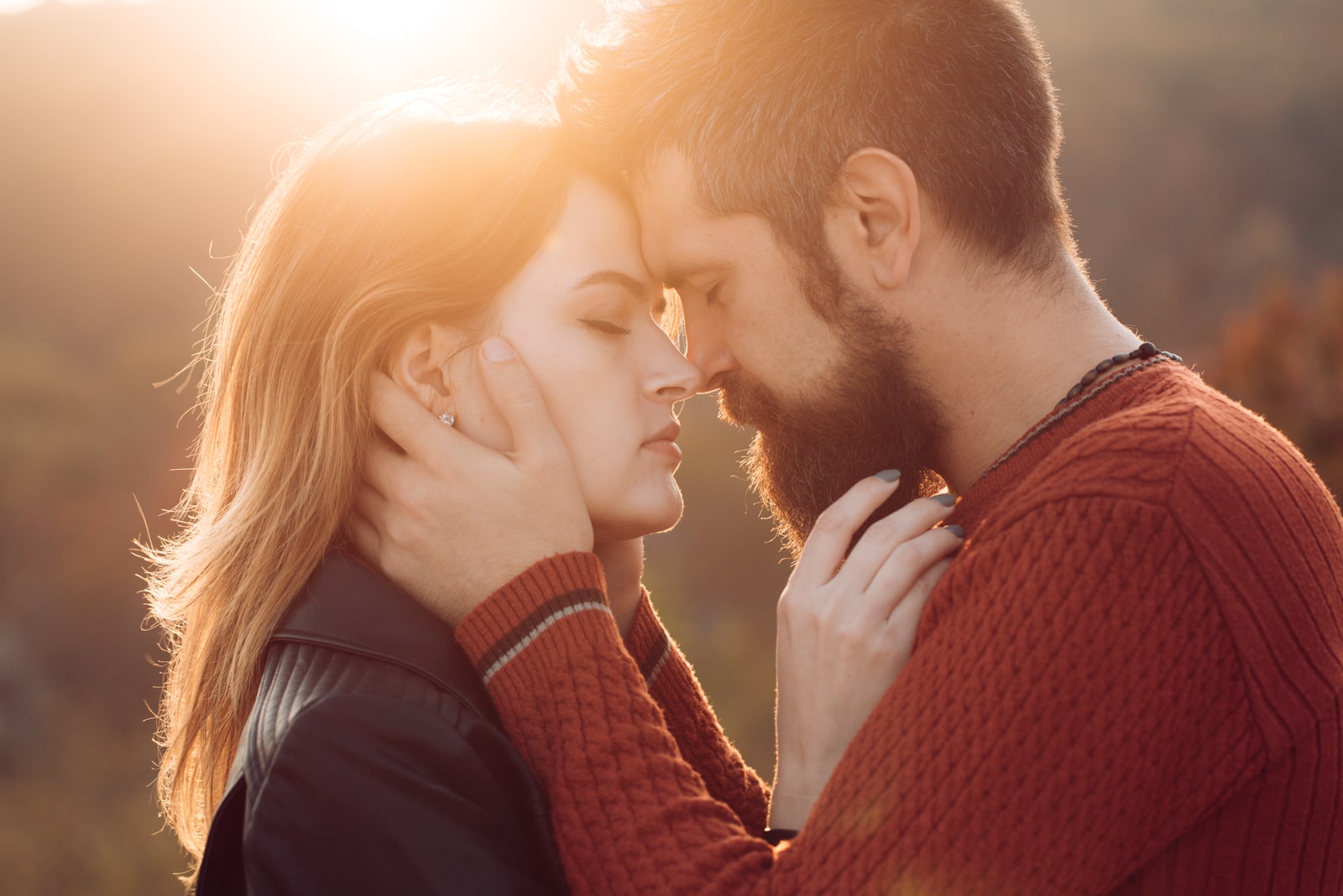 Man with beard holds womans head with tenderness