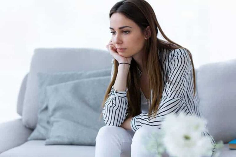 young woman sitting on the bed and thinking