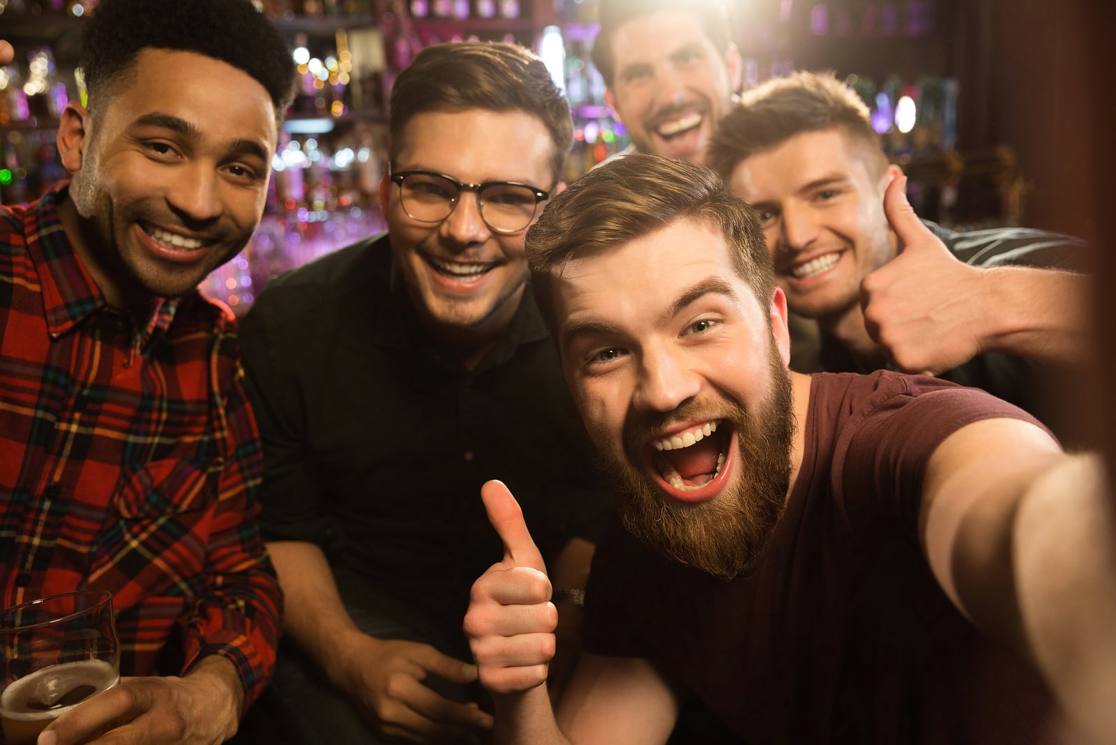 un grupo de amigos sonrientes se hacen una foto selfie en una cafetería