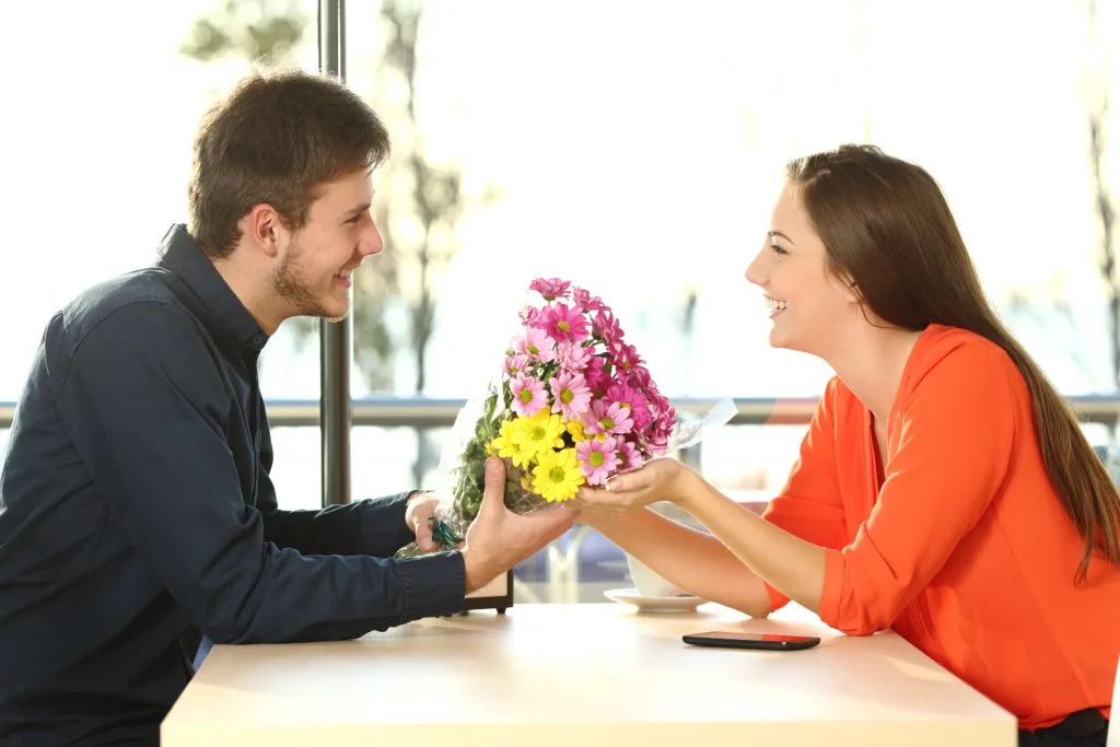 a man gives flowers to a girl