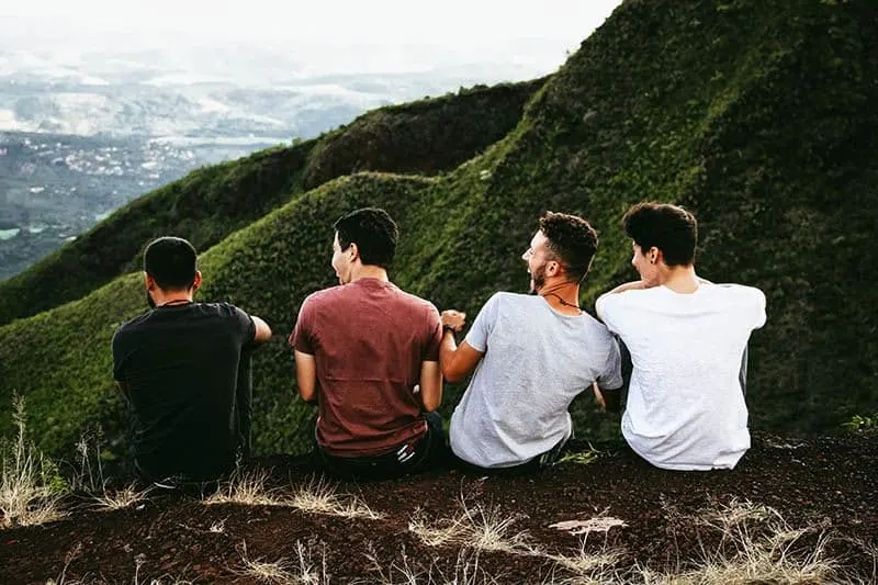 friends sitting in front of hills