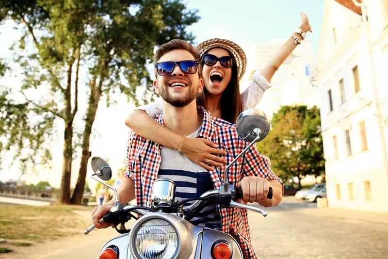 happy couple driving on motorbike