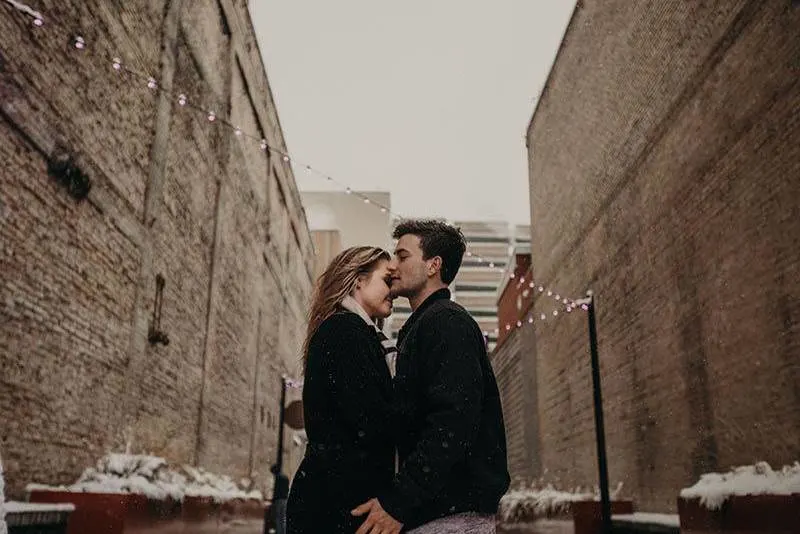 man and woman wearing black jacket and standing close to each other outside