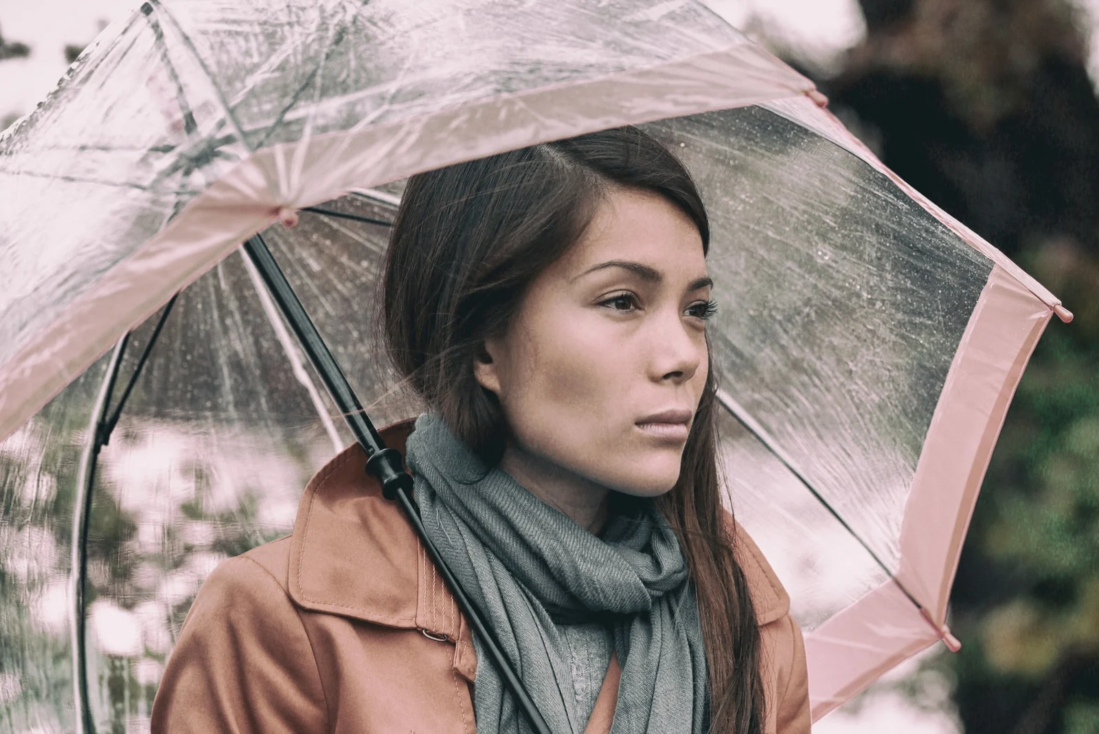pensive woman holding umbrella