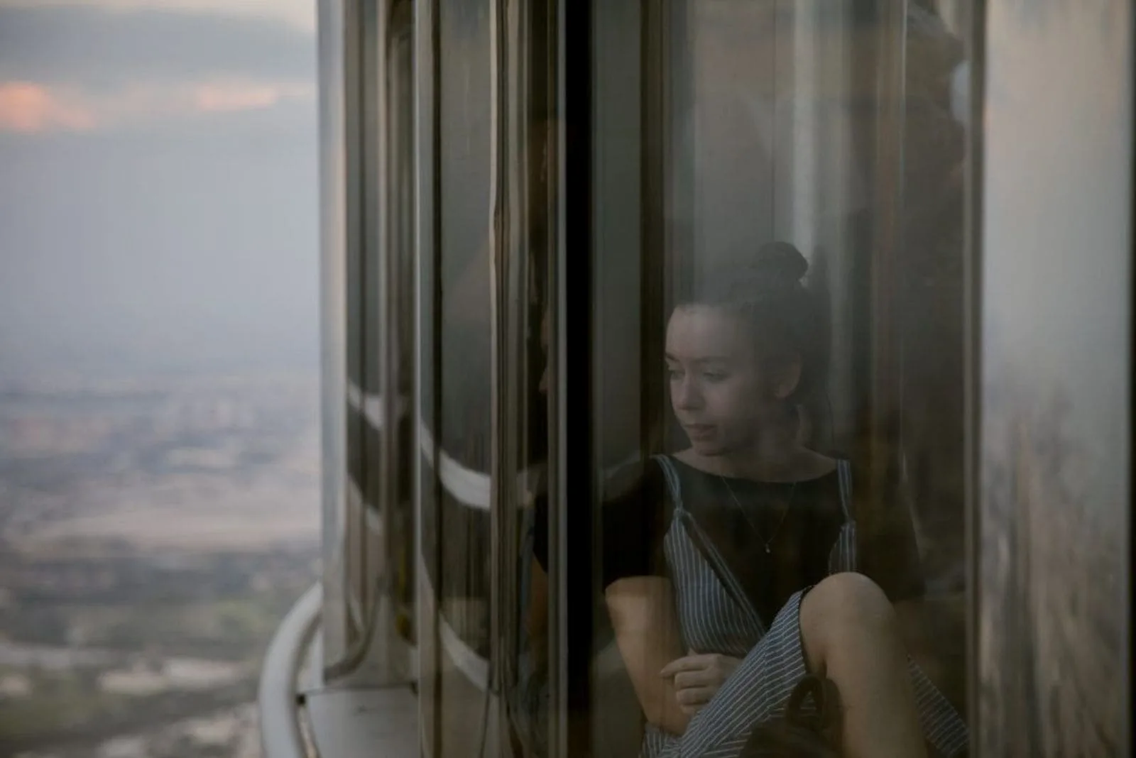 sad woman in skyscraper looking through the window
