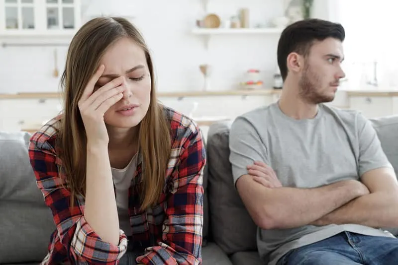 mulher triste sentada ao lado do homem no sofá