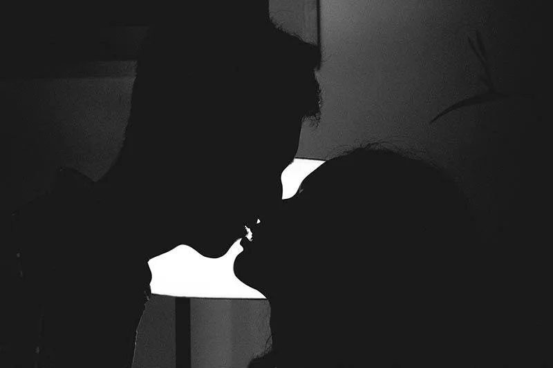 silhouette of couple kissing at home