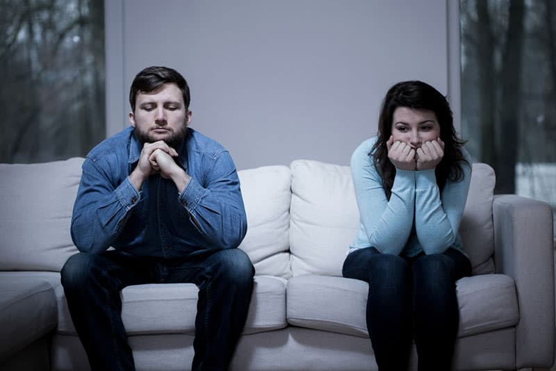 unhappy couple sitting on sofa