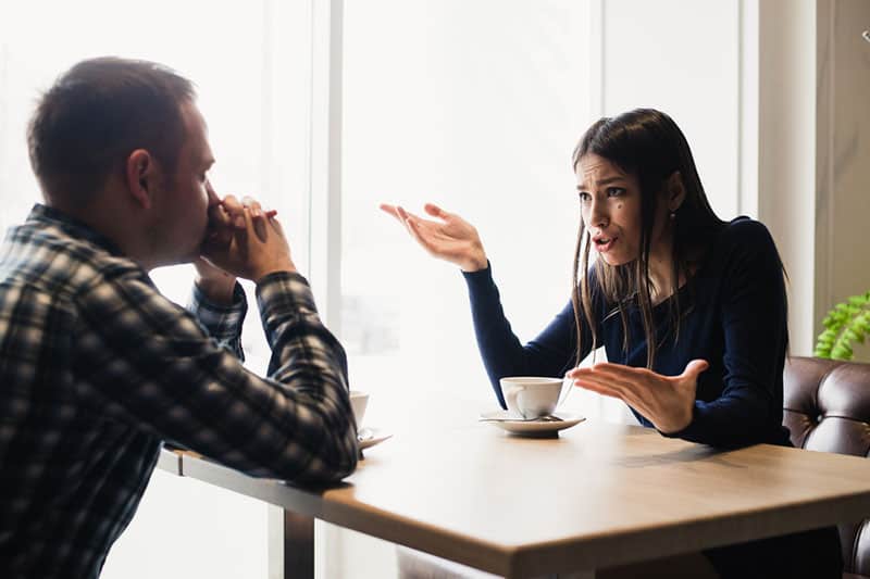 woman arguing with man in cafe