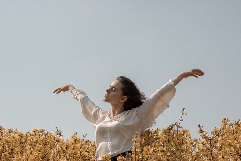 woman in flowers with eyes closed