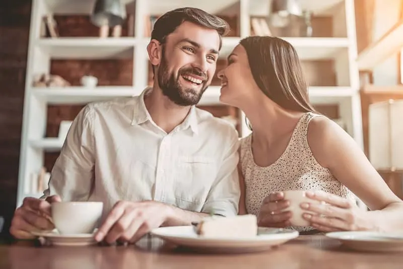 woman whispering to man