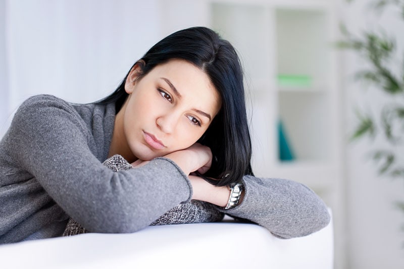 worried woman looking at distance in the living room