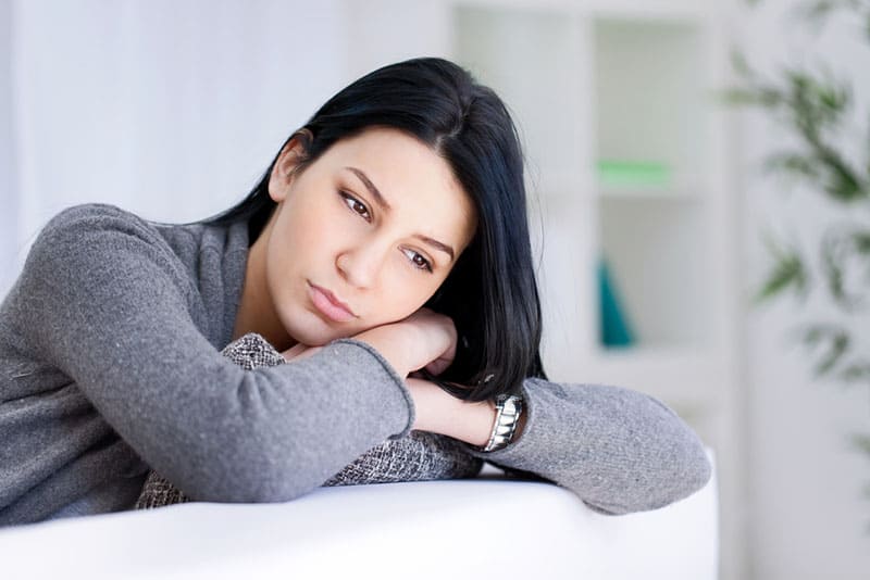 worried woman sitting on sofa