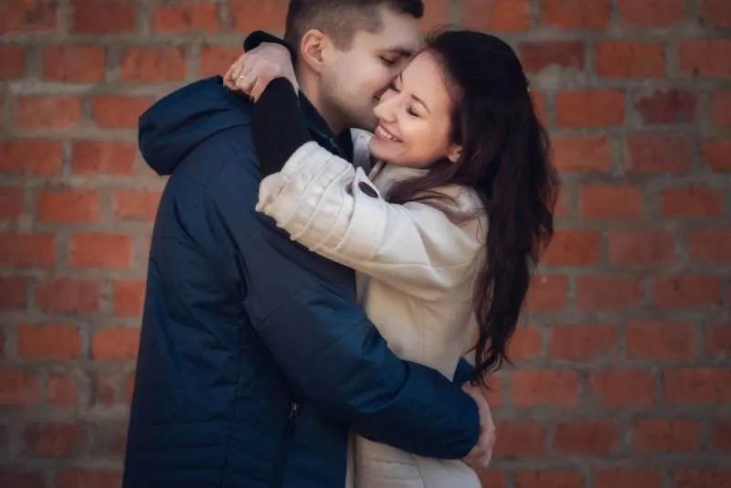 young couple hugging outside