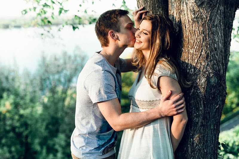 young man kissing woman in cheek