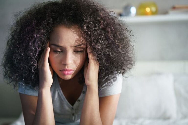 mulher preocupada com cabelo encaracolado em pensamentos profundos