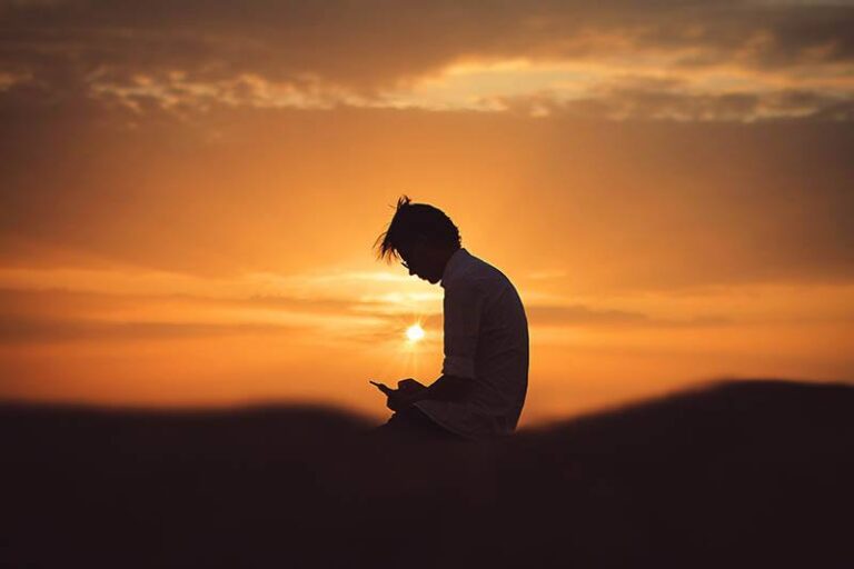 silhouette of man sitting during sunset