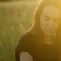 mujer triste en campo de hierba