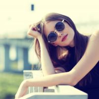 beautiful brunette with sunglasses standing on the terrace