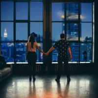 man and woman holding hands in front of glass window