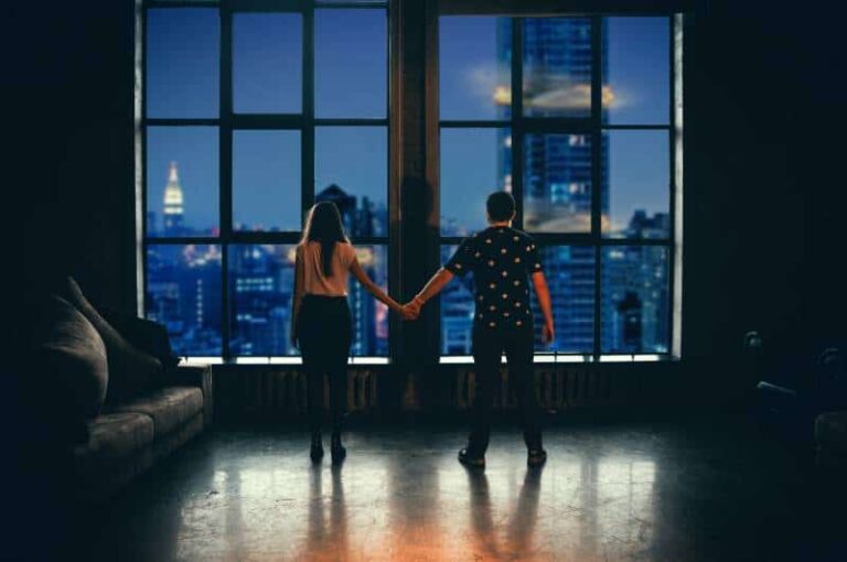 man and woman holding hands in front of glass window