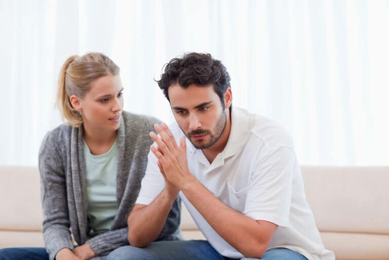 mujer rubia hablando con hombre triste
