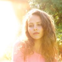 Portrait of attractive woman with long hair outside in bright sunlight