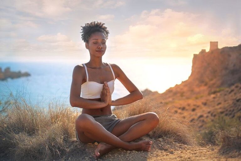 young woman meditates on the hill
