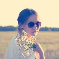 rapariga com óculos de sol e flores no exterior